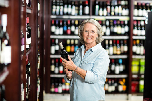 Woman choosing wine in a supermarket