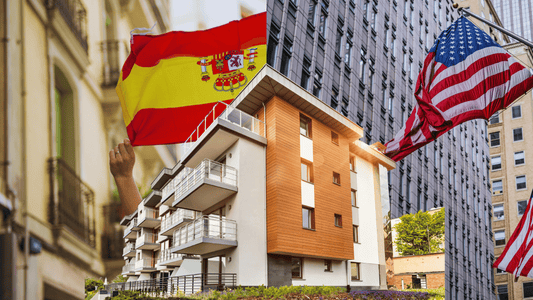 Spain and United States flags with modern apartment building, symbolizing Americans buying real estate in Spain