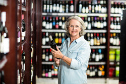 Woman choosing wine in a supermarket 