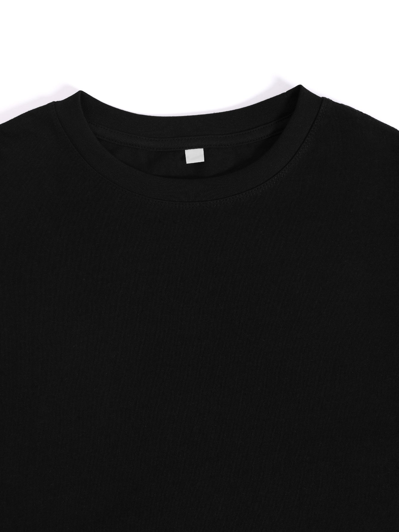 Close-up of a black shirt collar with a white label on a white background
