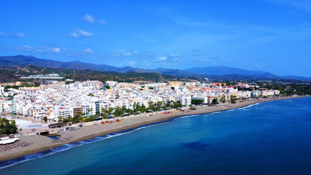 Aerial view across La Rada beach towards central Estepona and the mountains.